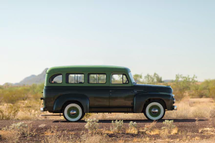 Classic green and black International Harvester R-110 Travelall station wagon SUV parked in a desert landscape, captured in 4K Ultra HD for a PC desktop wallpaper.