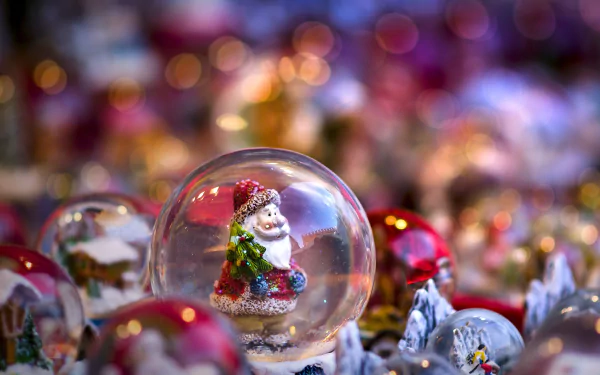 HD PC desktop wallpaper featuring a festive Santa inside a snow globe with colorful holiday bokeh lights creating a warm Christmas atmosphere.