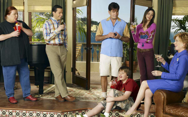 HD PC desktop wallpaper featuring the main cast of the TV show Two and a Half Men in a casual living room setting.