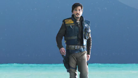 HD PC desktop wallpaper of a rugged rebel operative from the movie Rogue One standing on a turquoise shoreline beneath a starry sky.