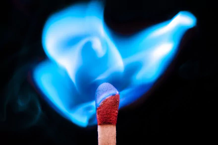 Close-up photography HD PC desktop wallpaper of a match head igniting with a vivid blue flame against a dark background.