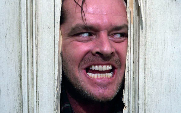 HD desktop wallpaper featuring Jack Nicholson as Jack Torrance from the movie The Shining, showing his intense expression through a broken door.