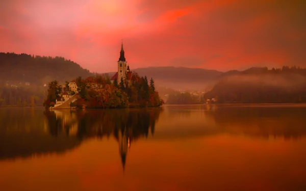 A serene image of Lake Bled in Slovenia with the Assumption of Mary Church reflecting on the calm water, bathed in a warm orange glow under an evening sky.