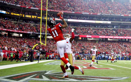 HD desktop wallpaper featuring Julio Jones in action during a football game, making a high catch on the field.
