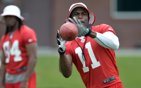 HD wallpaper featuring Julio Jones in a red jersey with the number 11, focused on catching a football during practice.