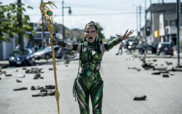 HD wallpaper of Elizabeth Banks as Rita Repulsa from the movie Power Rangers (2017), standing fiercely in the middle of a street with debris scattered around.