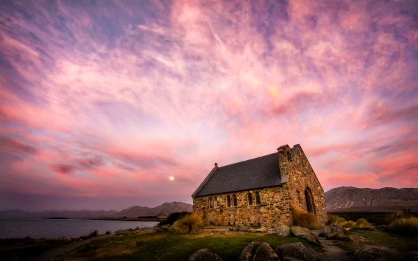 Sunset over Church of the Good Shepherd by Lake Tekapo, New Zealand, with vibrant skies and stone architecture in 4K Ultra HD.