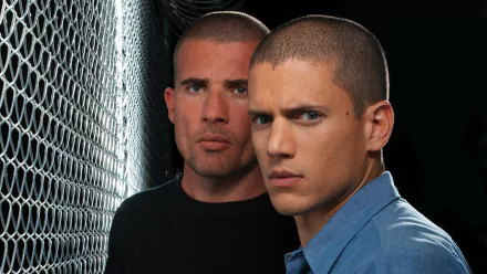 HD PC desktop wallpaper featuring Michael Scofield and Lincoln Burrows from the TV show Prison Break, set against a chain-link fence background.