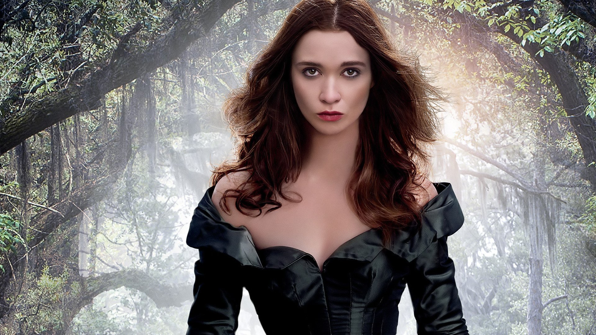 HD PC desktop wallpaper from the movie Beautiful Creatures featuring a woman with long dark hair in a black off-shoulder dress standing in an eerie, misty forest.