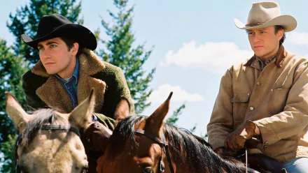 HD PC desktop wallpaper featuring a scene from the movie Brokeback Mountain with two cowboys on horseback against a natural landscape backdrop.
