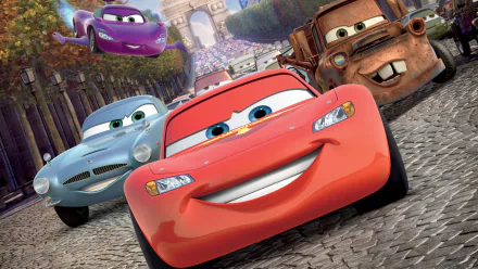 HD desktop wallpaper featuring characters from the movie Cars 2, with Lightning McQueen, Mater, and other cars racing through a cobblestone street near a grand arch.