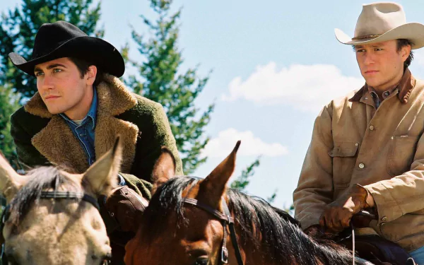 HD PC desktop wallpaper featuring a scene from the movie Brokeback Mountain with two cowboys on horseback against a natural landscape backdrop.