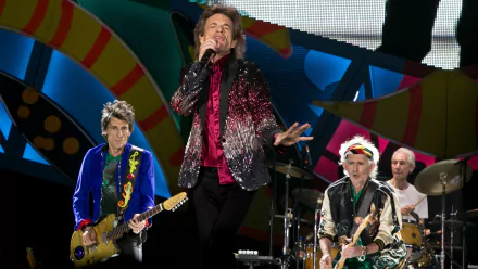 HD desktop wallpaper featuring The Rolling Stones performing live on stage with vibrant, colorful lighting and dynamic energy.