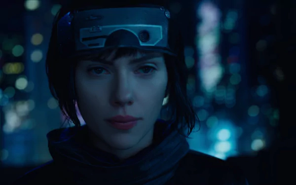 HD desktop wallpaper featuring Scarlett Johansson from the movie Ghost in the Shell (2017), with a futuristic cityscape background and Johansson in character wearing a headband and jacket.