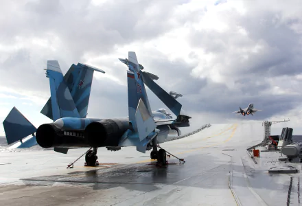 A 4K Ultra HD PC desktop wallpaper featuring a military Sukhoi Su-33 jet fighter warplane on an aircraft carrier deck under a cloudy sky.