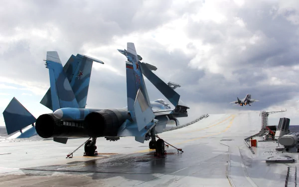 A 4K Ultra HD PC desktop wallpaper featuring a military Sukhoi Su-33 jet fighter warplane on an aircraft carrier deck under a cloudy sky.