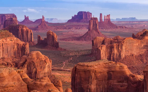 HD desktop wallpaper of Monument Valley in the USA, showcasing a stunning desert landscape with cliffs and rock formations under a clear blue sky.