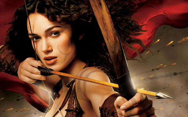 HD PC desktop wallpaper featuring a dramatic close-up of a female archer from the movie King Arthur, with intense expression and a backdrop of red fabric and arrows in flight.
