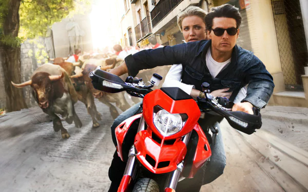 HD desktop wallpaper: action scene from the movie Knight and Day — two leads on a red motorcycle racing through a narrow street as bulls charge in pursuit.
