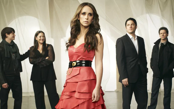 HD desktop wallpaper featuring the main cast of the TV show Ghost Whisperer, with Jennifer Love Hewitt as Melinda Gordon in a red dress at the center.