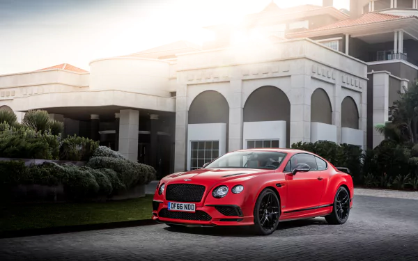 A red Bentley Continental car parked in front of an elegant building, captured in sharp detail as a 4K Ultra HD desktop wallpaper and background.