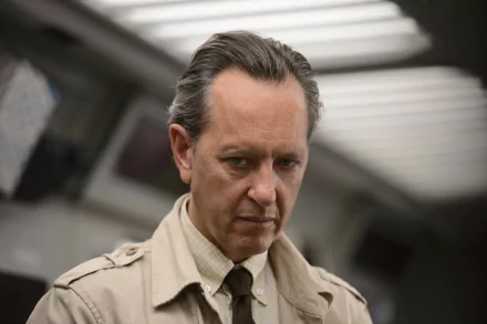 HD desktop wallpaper of Richard E. Grant as Dr. Zander Rice from the movie Logan, depicting a serious expression with a blurred background of a room.