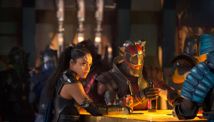 HD desktop wallpaper featuring Tessa Thompson from the movie Thor: Ragnarok, showing her character, Valkyrie, at a bar with other characters.