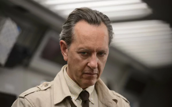HD desktop wallpaper of Richard E. Grant as Dr. Zander Rice from the movie Logan, depicting a serious expression with a blurred background of a room.