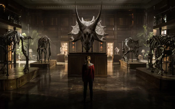 A scene from Jurassic World: Fallen Kingdom, featuring a character standing in an elegant room surrounded by dinosaur skeletons, creating a dramatic and captivating atmosphere.