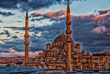 HD desktop wallpaper featuring the iconic Sultan Ahmed Mosque with its domes and minarets against a dramatic sunset sky in Istanbul, Turkey.