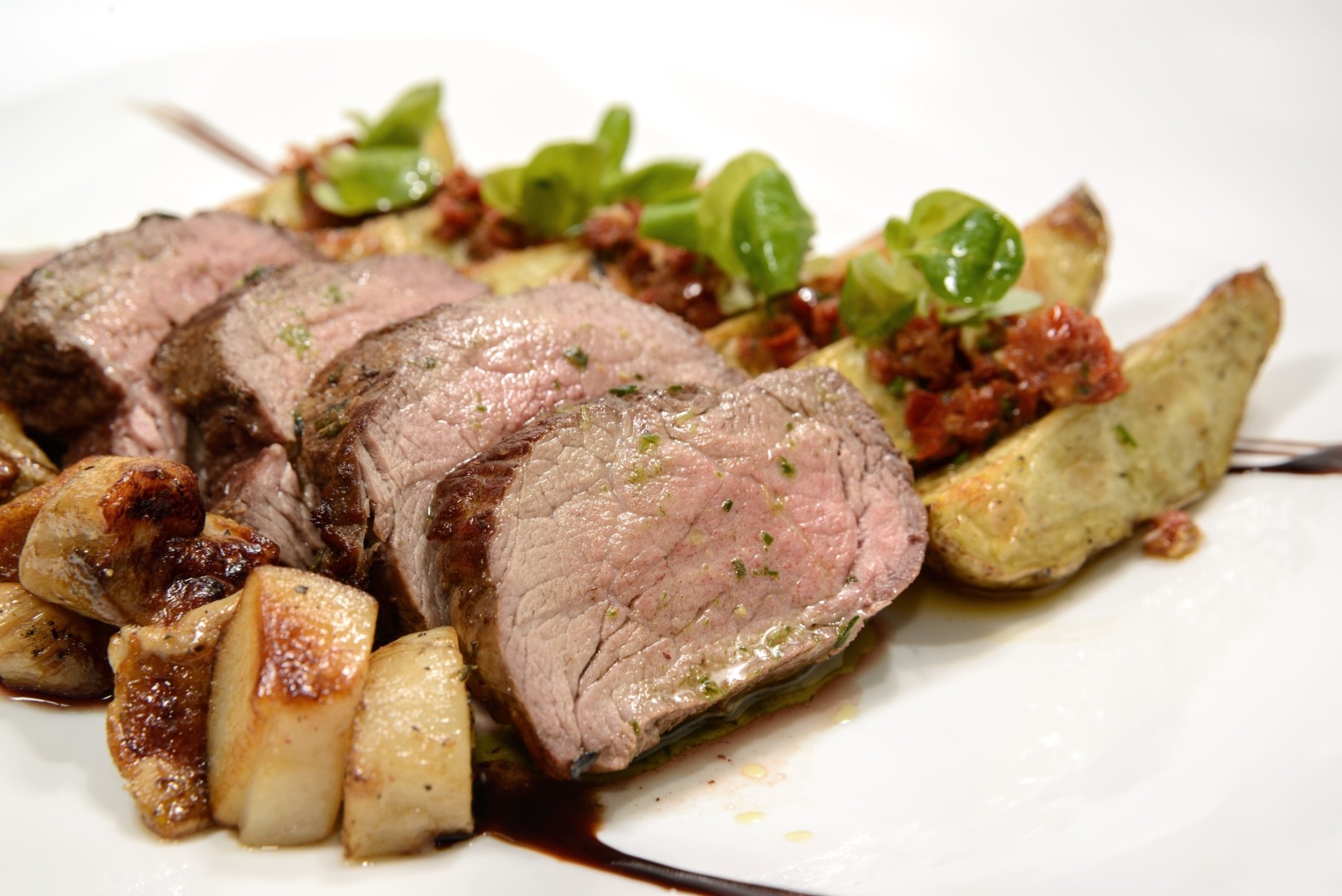 2K Quad HD PC desktop wallpaper: close-up of sliced roasted meat with pan-roasted potato wedges, mushrooms and microgreens on a white plate — food, potato, meat.