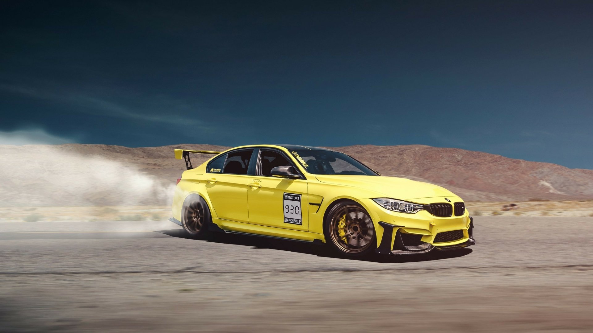 Yellow BMW M3 race car drifting on a desert track, captured in high-definition for a dynamic PC desktop wallpaper background.