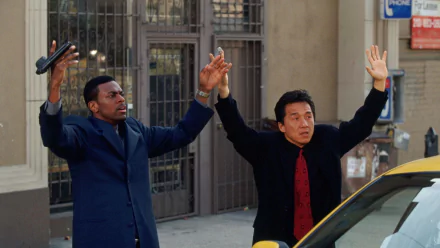 HD wallpaper featuring Chris Tucker and Jackie Chan in a scene from the movie Rush Hour, both with hands raised in a tense moment.