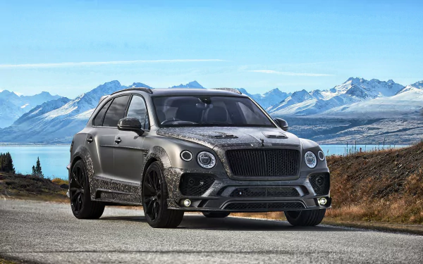 Silver Bentley Bentayga SUV parked on a roadside with snowy mountains and a lake in the background, captured in 4K Ultra HD for a PC desktop wallpaper.