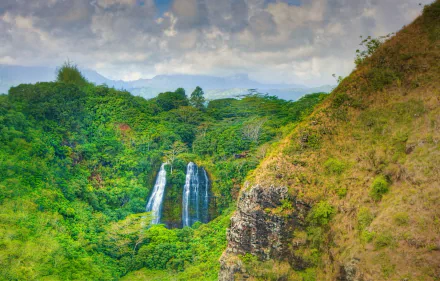 Opaeka'a Falls cascades through lush green forest and mountains in Kauai, Hawaii, captured in this HD desktop wallpaper showcasing vibrant nature and waterfall beauty.