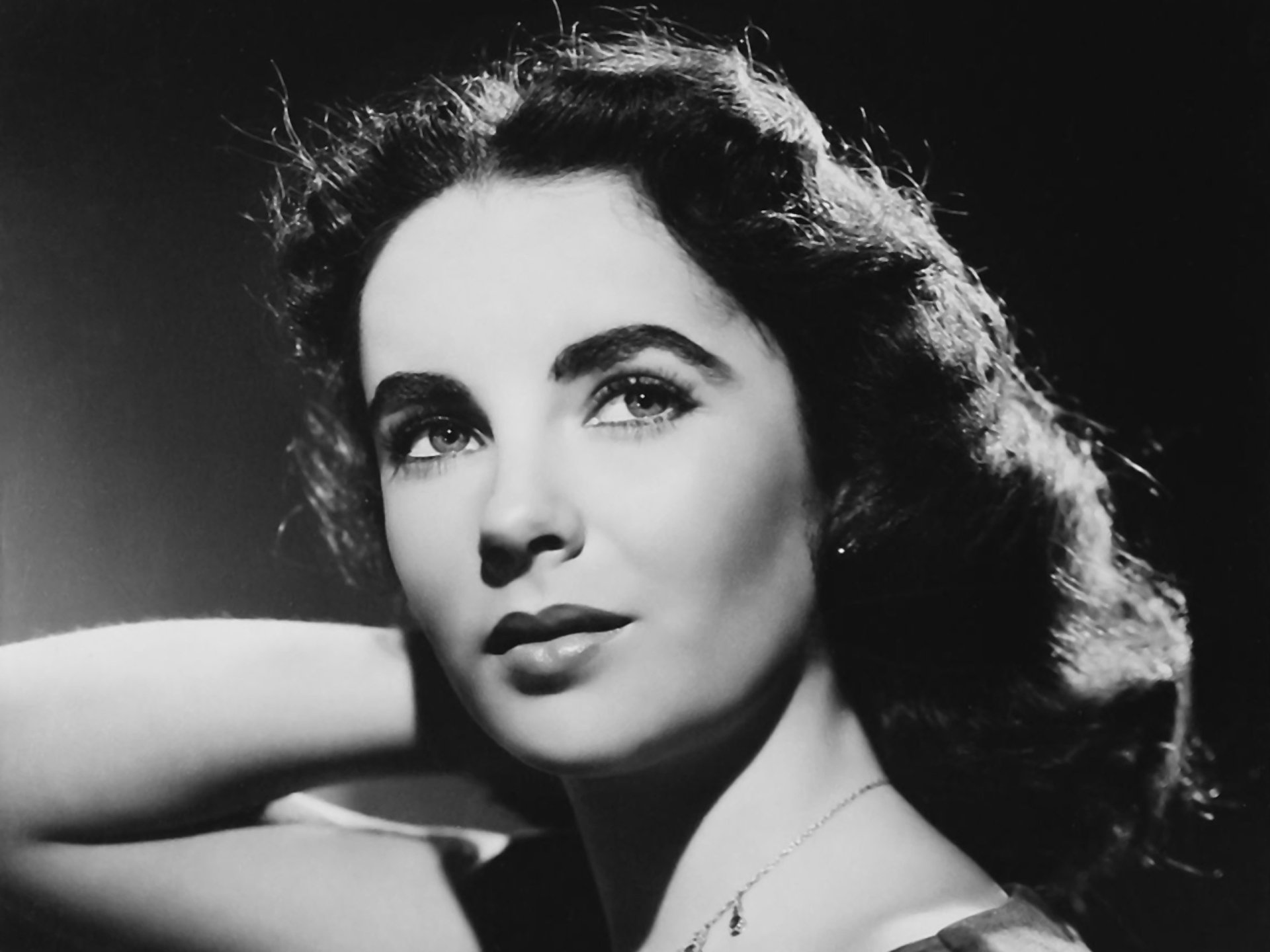 Black and white HD desktop wallpaper featuring a classic portrait of Elizabeth Taylor, capturing her timeless beauty and iconic celebrity presence.