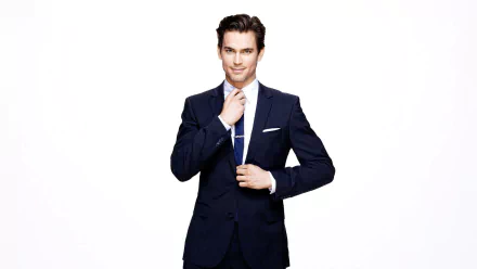 HD desktop wallpaper featuring a well-dressed man in a blue suit, adjusting his tie, against a white background.