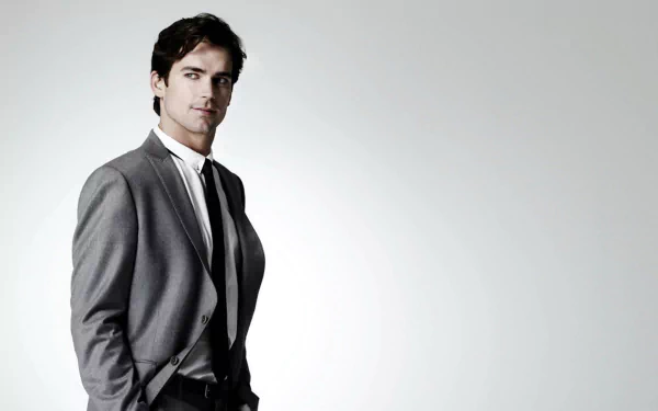 HD desktop wallpaper featuring a man in a gray suit against a light background.