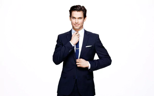 HD desktop wallpaper featuring a well-dressed man in a blue suit, adjusting his tie, against a white background.