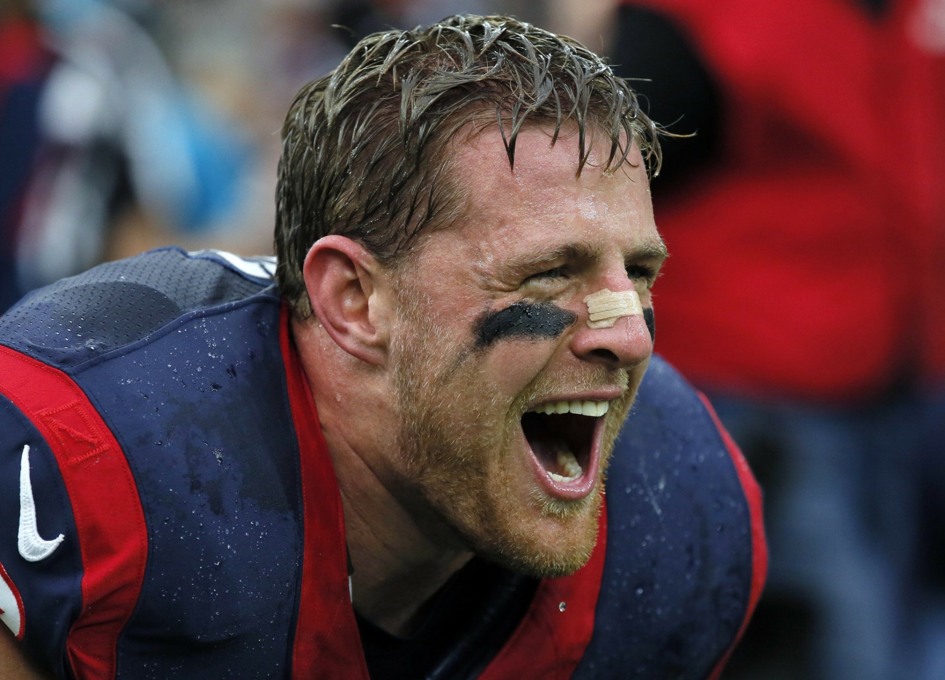 HD PC desktop wallpaper: close-up of a Houston Texans football player yelling on the sideline, rain-slicked uniform and eye black — a gritty sports background.