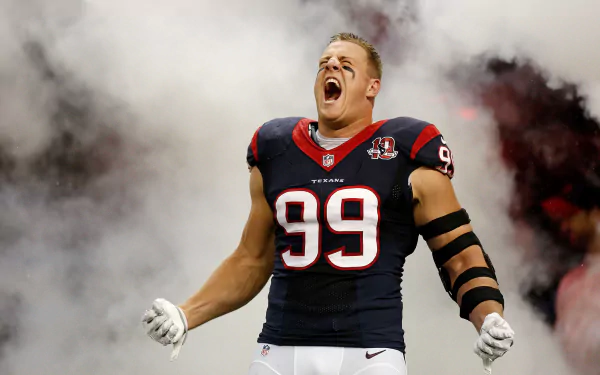 Houston Texans player J.J. Watt in full gear celebrates passionately on an HD sports desktop wallpaper with smoky background effects.