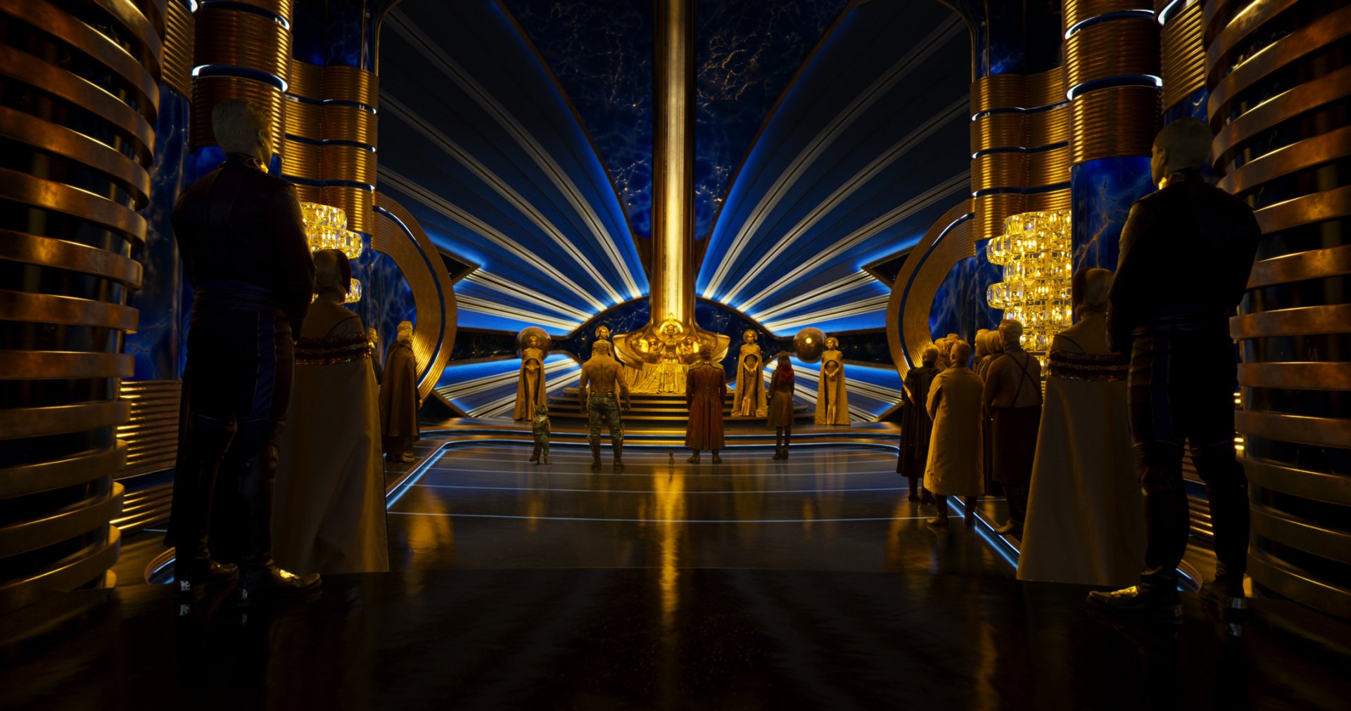 Ayesha and the Sovereign stand in an ornate, golden chamber from Guardians of the Galaxy Vol. 2, featuring rich lighting and futuristic architectural design.