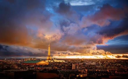 HD desktop wallpaper of Paris cityscape at twilight with the Eiffel Tower illuminated. The sunset creates a dramatic sky with clouds and vibrant colors.