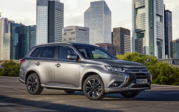 Silver Mitsubishi Outlander SUV parked in front of a city skyline, captured in 4K Ultra HD for a PC desktop wallpaper background.