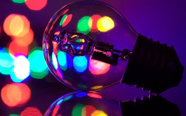 Close-up 4K Ultra HD image of a light bulb reflecting colorful bokeh lights on a dark background, creating a vibrant and artistic man-made scene.