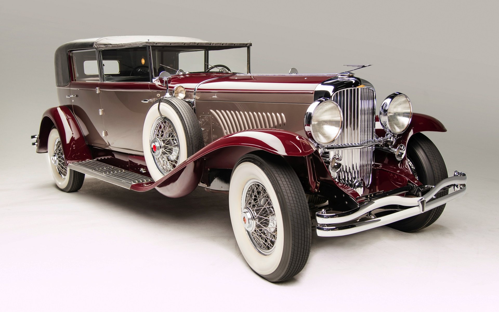 A classic Duesenberg Model J car in burgundy and chrome, showcased as a 4K Ultra HD desktop wallpaper and background.