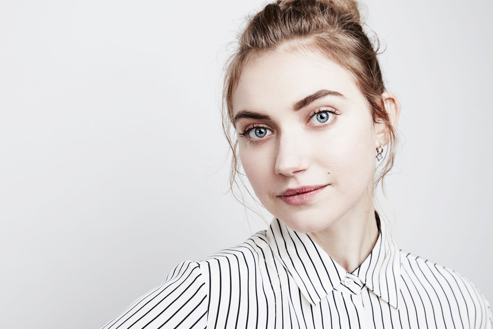A high-definition desktop wallpaper featuring the English actress Imogen Poots with blue eyes, wearing a striped shirt, and posing against a neutral background.