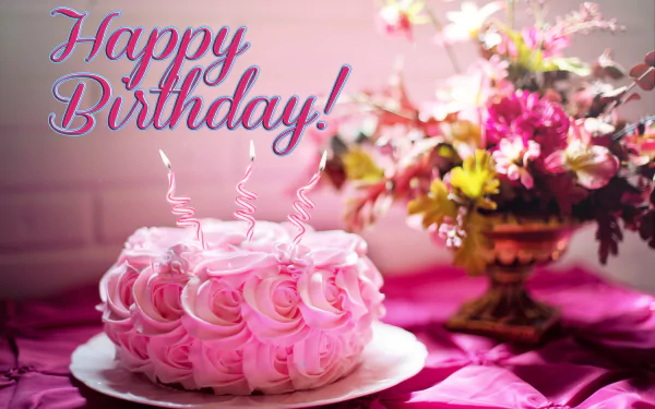 HD desktop wallpaper of a festive birthday scene with a pink rose-decorated cake and Happy Birthday! text, set against a background featuring a vibrant floral arrangement.