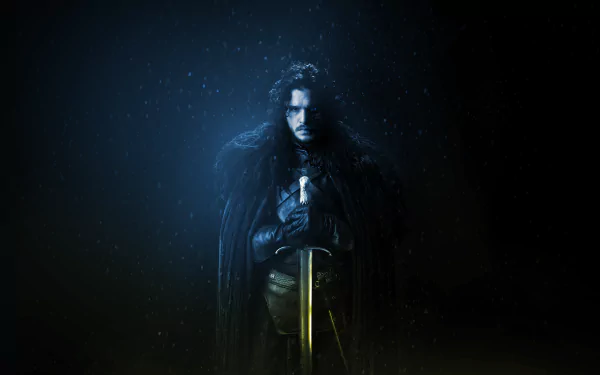 HD desktop wallpaper featuring Kit Harington as Jon Snow from the TV show Game of Thrones, standing solemnly with a sword against a dark, snowy background.