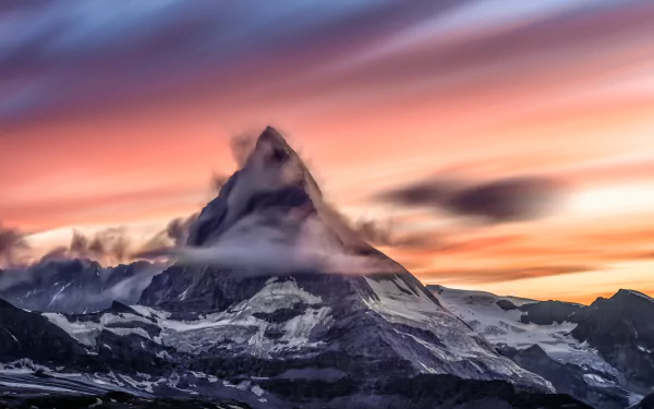 4K Ultra HD wallpaper of the Matterhorn mountain peak rising sharply from snowy cliffs, framed by vibrant clouds and a colorful sky at sunrise or sunset.